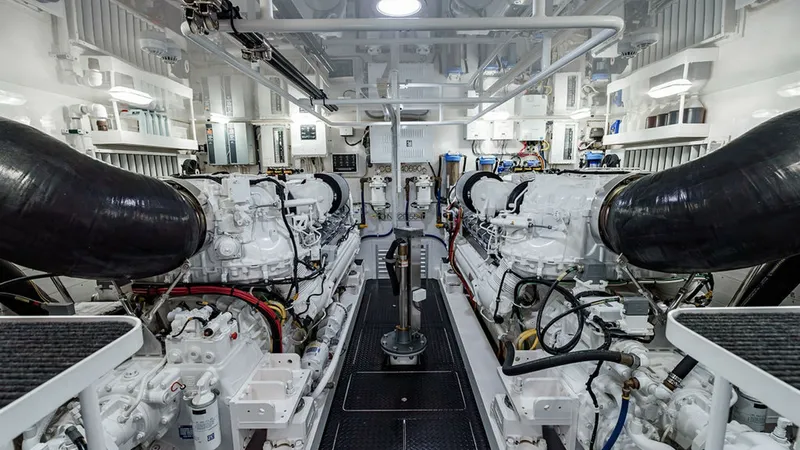 Slide: The Image of Engine Room with Twin Engines The engine room of the 2019 Viking 80 Skybridge 'PARTY OF FIVE' showcases twin powerful engines, meticulously arranged for optimal performance. The area is well-lit, highlighting the pristine condition and organized layout of the machinery and components. - 6478752