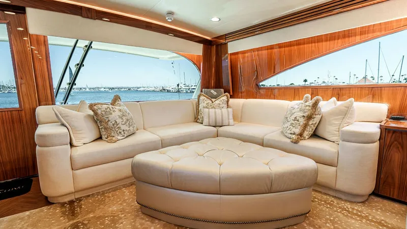 Slide: The Image of Luxurious Main Salon Lounge Area The main salon of the 2019 Viking 80 Skybridge, PARTY OF FIVE, features a spacious and inviting lounge area with plush L-shaped seating. The elegant wood paneling and large windows provide a warm ambiance and stunning views of the surrounding seascape. A - 6478705