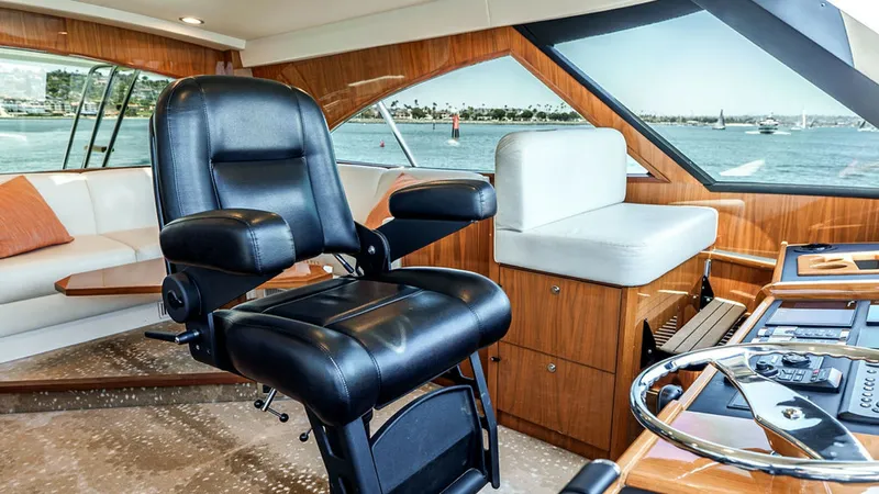 Slide: The Image of Skybridge Helm Station The helm station of the 2019 Viking 80 Skybridge features a luxurious captain's chair and panoramic views. The polished wood finishes and state-of-the-art navigation controls enhance the sophisticated ambiance. Comfortable seating surrounds the area, prov - 6478742