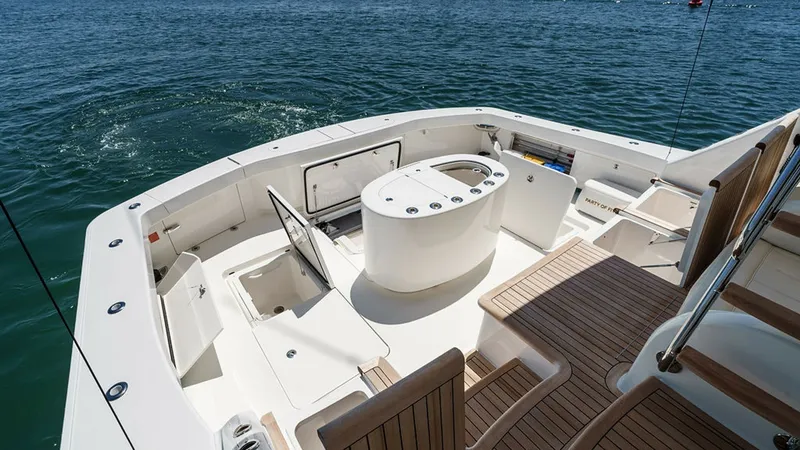 Slide: The Image of Spacious Aft Deck with Seating Area The aft deck of the 2019 Viking 80 Skybridge offers a luxurious and functional space for entertaining. Featuring rich teak flooring and ample seating, this area is perfect for social gatherings or relaxing while taking in the view. The central console pro - 6478756