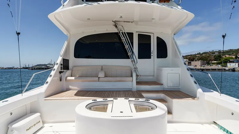 Slide: The Image of Aft Deck with Seating and Access The aft deck of the 2019 Viking 80 Skybridge, PARTY OF FIVE, features an inviting seating area with plush cushions, perfect for relaxation and entertaining. The teak flooring adds a touch of elegance and durability, while the sleek staircase provides easy - 6478703