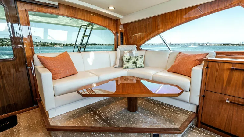 Slide: The Image of Salon with Panoramic Windows and Seating The salon of the 2019 Viking 80 Skybridge features plush L-shaped seating with elegant accent pillows, perfect for relaxation and socializing. Large panoramic windows provide breathtaking views of the surrounding waters, enhancing the open and airy feel o - 6478743