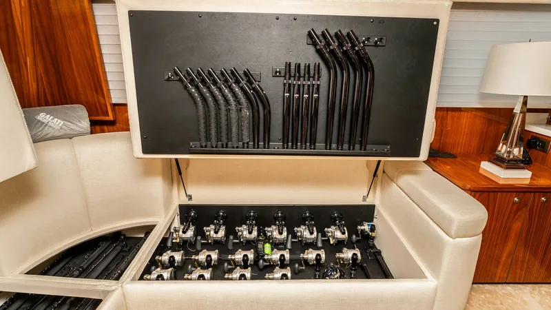 Slide: The Image of Integrated Fishing Rod Storage This image showcases the sophisticated fishing rod storage system onboard the 2019 Viking 80 Skybridge, PARTY OF FIVE. The neatly organized compartment is built into the plush seating area, offering both convenience and elegance. High-quality materials an - 6613313