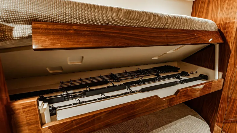 Slide: The Image of Guest Cabin Rod Storage Drawer This image showcases the intelligent design of the guest cabin's rod storage drawer on the 2019 Viking 80 Skybridge. The drawer, built into the cabinetry beneath the bunk bed, offers organized storage for fishing rods, ensuring they are safely stowed yet - 6478730