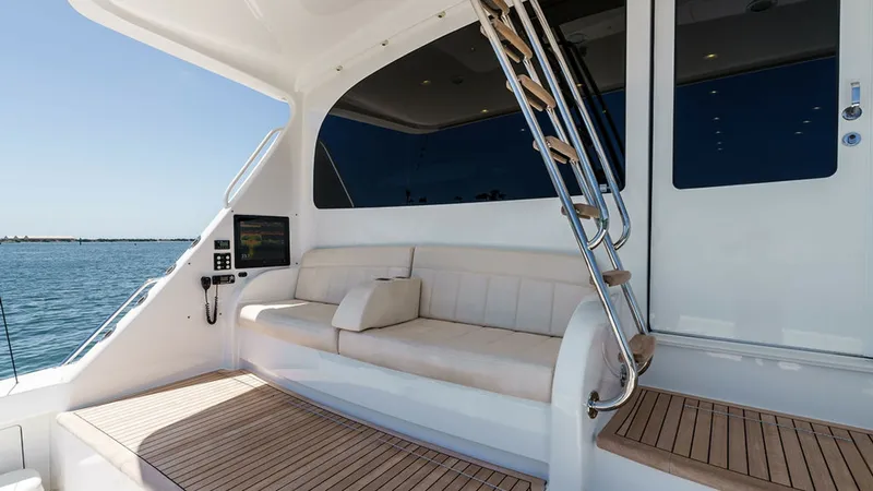 Slide: The Image of Aft Deck with Seating Area This spacious aft deck on the 2019 Viking 80 Skybridge, PARTY OF FIVE, features elegant teak flooring and a plush, built-in seating area. The sleek stainless steel staircase provides easy access to the upper levels, while large windows offer expansive vie - 6478764