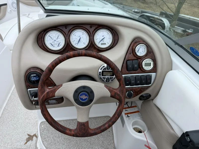 Slide: The Image of Four-Winns-250-Horizon-Helm-Station-Electronics The helm station of the 2005 Four Winns 250 Horizon, featuring a comprehensive analog gauge suite, wood-grain accents, and dual bucket seats with flip-up bolsters. Includes controls for the upgraded marine audio system. - 5970682