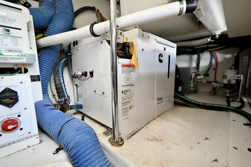 Slide: The Image of Generator and Systems Installation, Cruisers Yachts 38 GLS The mechanical space includes an onboard generator, providing reliable AC power for systems such as air conditioning, galley equipment, and onboard electronics while away from shore power. The unit is securely mounted and positioned for accessibility with - 6003110