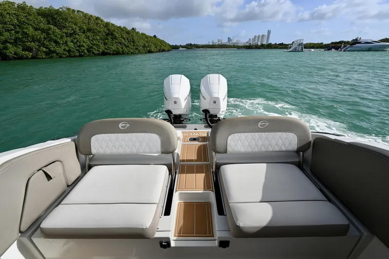 Slide: The Image of Convertible aft seating with dual sun pads and teak-style walkthrough. Comfortable lounging space with open views aft and easy access to the swim platform. - 6024939