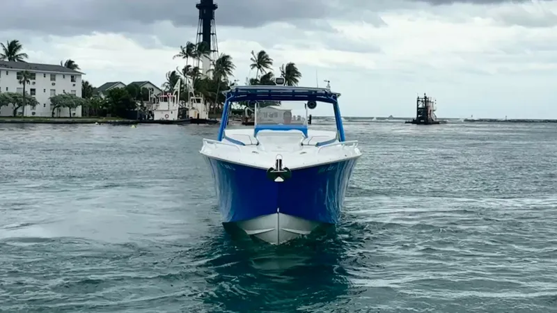 Slide: The Image of Front View of Midnight Express 39S The 2016 Midnight Express 39S Cuddy is showcased from a striking frontal perspective, highlighting its sleek hull design and vibrant blue color. The image captures the vessel's wide beam and sturdy construction, ideal for navigating open waters with confi - 6311138