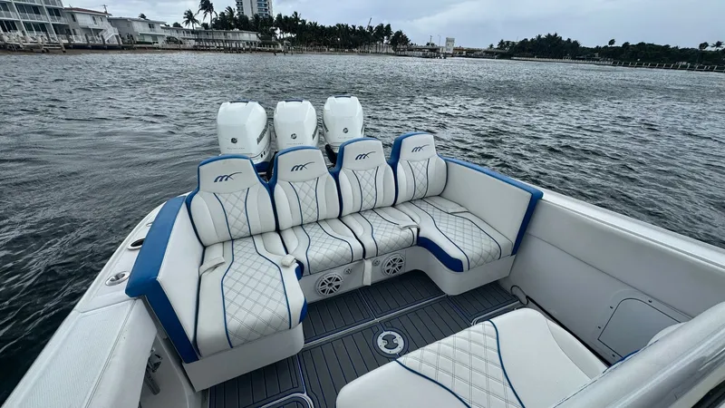 Slide: The Image of Aft Deck Seating and Engines The aft deck of this 2016 Midnight Express 39S Cuddy features luxurious cushioned seating with elegant blue piping and diamond-stitched upholstery, providing comfort and style. Behind the seating, three powerful outboard engines promise superior performan - 6311148