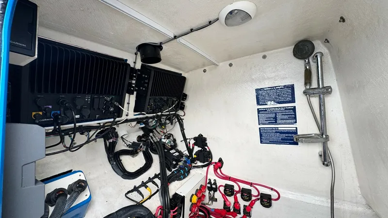 Slide: The Image of Technical Compartment with Electrical Systems This image showcases the technical compartment of the 2016 Midnight Express 39S Cuddy, highlighting its neatly organized electrical systems. The compartment features advanced wiring and control units, ensuring efficient operation and easy access for maint - 6311152