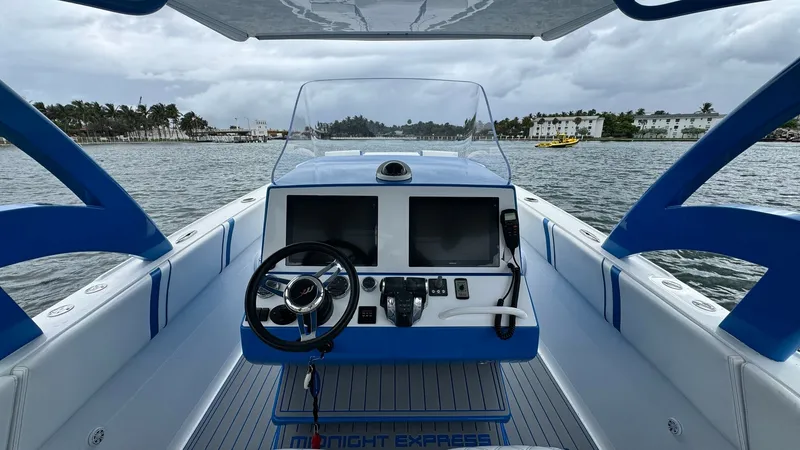 Slide: The Image of Helm Station with Dual Displays The helm station of the 2016 Midnight Express 39S Cuddy features dual large displays, offering comprehensive navigation and system monitoring. The ergonomic design includes a stylish steering wheel and easy access to controls, enhancing the driving experi - 6311139