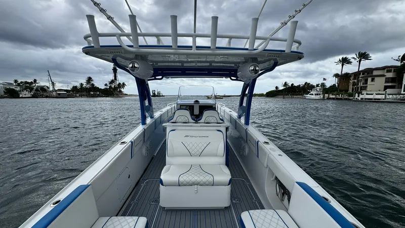 Slide: The Image of Spacious Cockpit with Helm Seating The 2016 Midnight Express 39S Cuddy features a spacious cockpit with sleek, modern helm seating. The seating is adorned with diamond-stitched upholstery, offering both comfort and style. Overhead, a sturdy T-top provides shade and houses multiple rod hold - 6311141