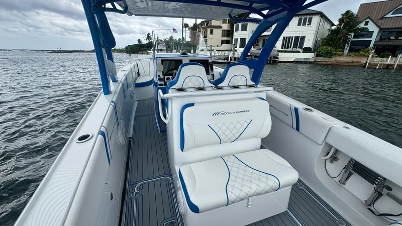 Slide: The Image of Spacious Cockpit with Seating The 2016 Midnight Express 39S Cuddy offers a sleek and spacious cockpit, featuring comfortable, upholstered seating with distinctive blue accents. The helm is equipped with modern controls, ensuring a smooth navigation experience. This area is perfect for - 6311143