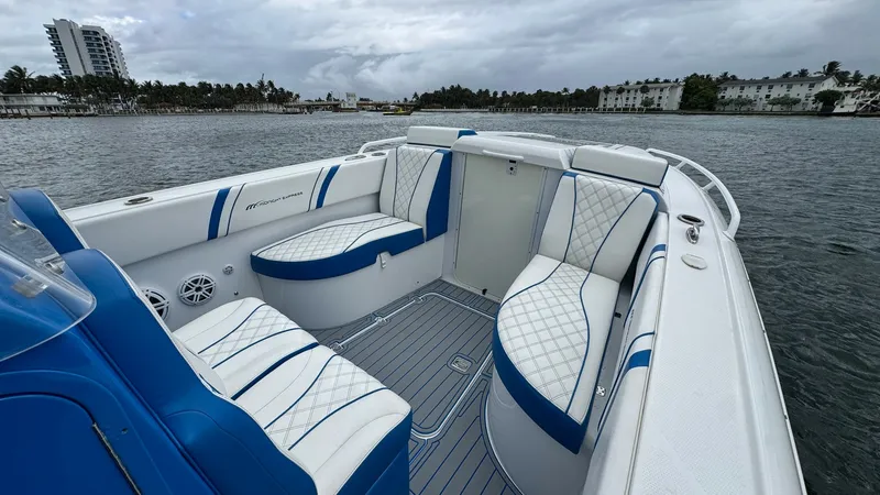 Slide: The Image of Spacious Aft Seating Area This 2016 Midnight Express 39S Cuddy features a luxurious aft seating area with elegant, diamond-stitched upholstery in white and blue. The layout offers ample space for relaxation, with comfortable bench seating and high-quality marine-grade materials. P - 6311145
