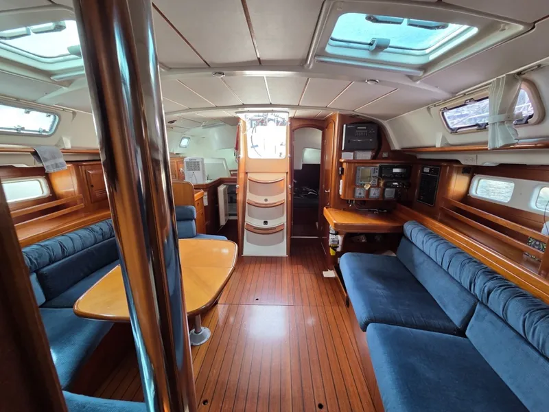 Slide: The Image of Interior of a 2000 Beneteau Oceanis 411 sailboat with cherry wood finish and blue upholstery - 6257938