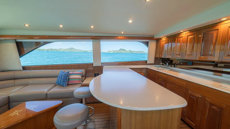 Slide: The Image of Spacious Salon with Ocean Views The salon of the 2005 Viking 61 Convertible 'Honey Girl' features a luxurious open layout with panoramic ocean views. The elegant wood cabinetry and plush seating create a welcoming atmosphere, while the expansive countertop provides ample space for enter - 6449512
