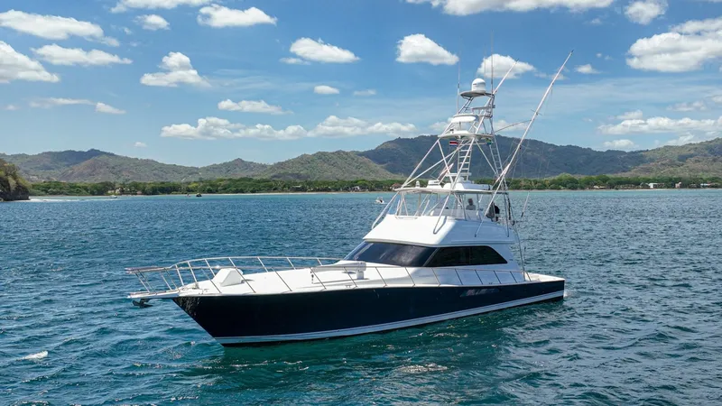 Slide: The Image of Starboard View of Viking 61 Convertible This image showcases the starboard side of the 2005 Viking 61 Convertible, 'Honey Girl'. The vessel's sleek, powerful lines are complemented by a robust fishing tower, ideal for offshore adventures. With its striking deep blue hull and spacious foredeck, - 6449587