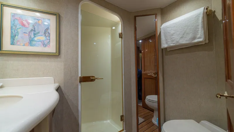 Slide: The Image of Luxurious Ensuite Head This elegant ensuite head features a spacious shower with a glass door and a sleek vanity with polished fixtures. The warm wooden flooring and tasteful wall art add a touch of sophistication, while the full-length mirror enhances the sense of space. Soft, - 6449540