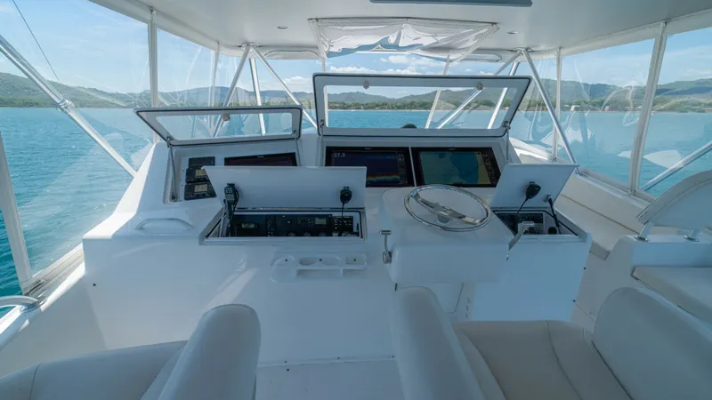 Slide: The Image of Flybridge Helm with Electronics Suite The flybridge helm of the 2005 Viking 61 Convertible 'Honey Girl' showcases a state-of-the-art electronics suite with multiple large display screens for navigation and monitoring. The spacious area features comfortable seating, allowing for optimal visibi - 6449565