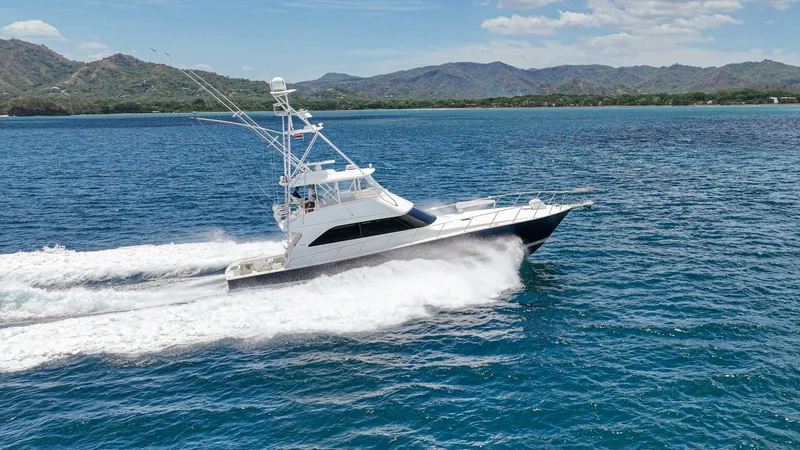 Slide: The Image of Viking 61 Convertible Cruising View The 2005 Viking 61 Convertible, 'Honey Girl', is captured cruising elegantly through the open water. Its sleek hull and robust tower are designed for both performance and style, offering a commanding presence on the sea. The vessel showcases its exception - 6449603