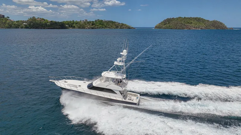 Slide: The Image of Aerial View of Viking 61 in Motion The 2005 Viking 61 Convertible 'Honey Girl' is captured cruising through open waters, showcasing its sleek design and powerful performance. The vessel's dynamic profile is complemented by the sturdy flybridge and spacious aft deck, ideal for sportfishing - 6449601