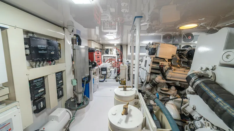 Slide: The Image of Engine Room with Advanced Systems The engine room of the 2005 Viking 61 Convertible 'Honey Girl' showcases a meticulously maintained space with advanced mechanical systems. The layout includes high-quality fuel filters, well-organized wiring, and robust machinery, ensuring optimal perform - 6449553