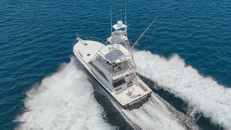 Slide: The Image of Aerial View of Aft Deck in Motion The 2005 Viking 61 Convertible, Honey Girl, showcases its impressive aft deck from an aerial perspective, cutting through the water with power and grace. The spacious open cockpit is designed for optimal sportfishing, equipped with essential gear and ampl - 6449600