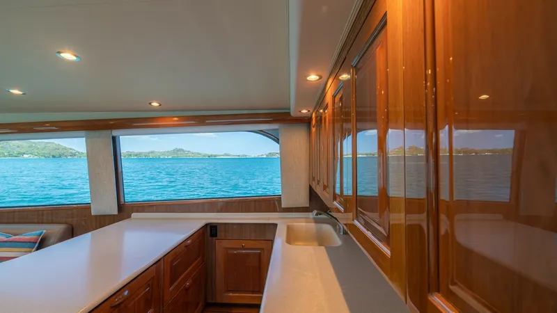 Slide: The Image of Galley with Ocean View This well-appointed galley on the 2005 Viking 61 Convertible features rich wooden cabinetry and expansive countertops, providing ample storage and workspace. The large windows offer stunning ocean views, creating a bright and inviting space. Recessed ligh - 6449515