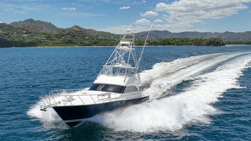 Slide: The Image of Viking 61 Convertible Cruising The Honey Girl, a 2005 Viking 61 Convertible, cuts through the water with impressive power and elegance. Featuring a sleek design with a flybridge, this vessel is built for speed and comfort. The blue hull contrasts beautifully with the white superstructu - 6449597