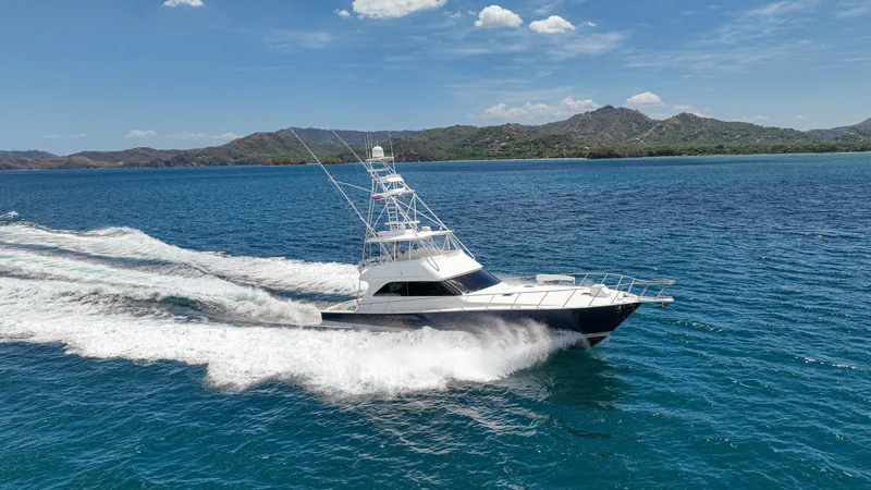 Slide: The Image of Aerial View of Viking 61 Convertible This dynamic aerial shot showcases the Viking 61 Convertible slicing through the water with impressive speed and agility. The sleek design and powerful performance are evident, highlighted by the boat's streamlined hull and commanding tower. Set against a - 6449604