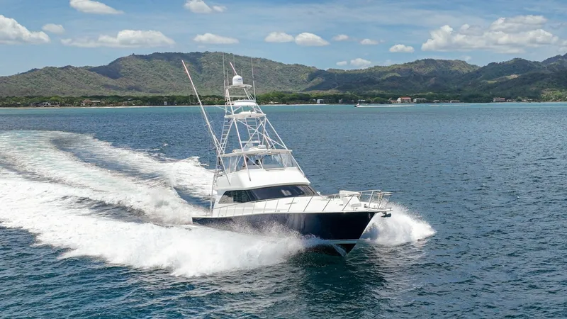 Slide: The Image of Viking 61 Convertible at Sea The 2005 Viking 61 Convertible 'Honey Girl' is captured elegantly cutting through the water, showcasing its powerful performance and sleek design. With a towering flybridge and robust hull, this vessel exemplifies Viking's craftsmanship and engineering pr - 6449595