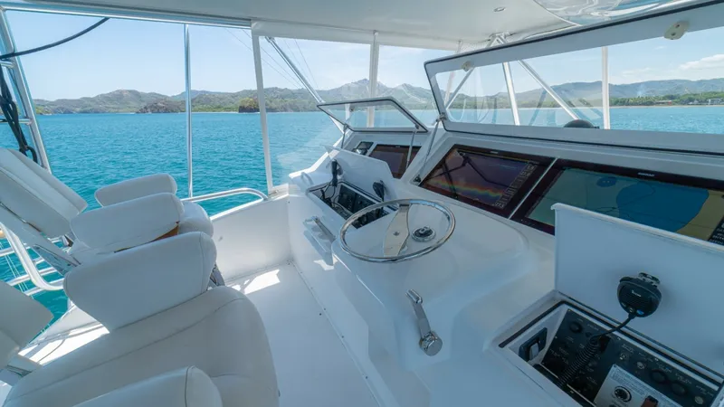 Slide: The Image of Flybridge Helm Station with Electronics The flybridge helm station of the 2005 Viking 61 Convertible 'Honey Girl' features an array of advanced electronics and navigation systems, providing seamless control. The dual helm seats offer comfort and visibility, while the panoramic windows ensure an - 6449567