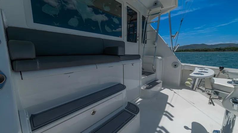 Slide: The Image of Spacious Aft Cockpit with Seating This image showcases the aft cockpit of the 2005 Viking 61 Convertible, featuring comfortable bench seating and ample space for entertaining. The clean, white finishes are complemented by stainless steel accents, enhancing the vessel's modern aesthetic. T - 6449556