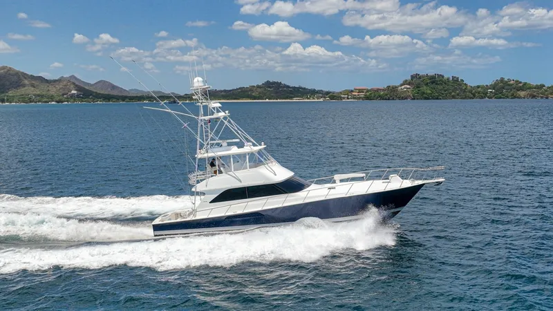 Slide: The Image of Viking 61 Convertible at Sea The 2005 Viking 61 Convertible, Honey Girl, cuts through the water with impressive speed and elegance. Its sleek profile and robust hull design are perfectly complemented by the flybridge, offering panoramic views and superior navigational capabilities. T - 6449593
