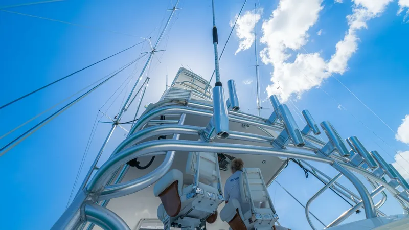 Slide: The Image of Tower and Helm Stations View This image showcases the impressive tower and helm stations of the 2005 Viking 61 Convertible, 'Honey Girl'. The sleek, polished metal and ergonomic seating highlight the vessel's robust design and attention to detail. The clear blue sky provides a stunni - 6449562