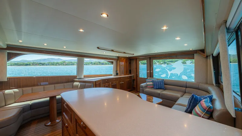 Slide: The Image of Spacious Salon with Panoramic Views This elegant salon aboard the 2005 Viking 61 Convertible 'Honey Girl' features a luxurious and spacious seating area with plush, wrap-around sofas. Large windows flood the space with natural light and offer stunning panoramic views of the surrounding wate - 6449516