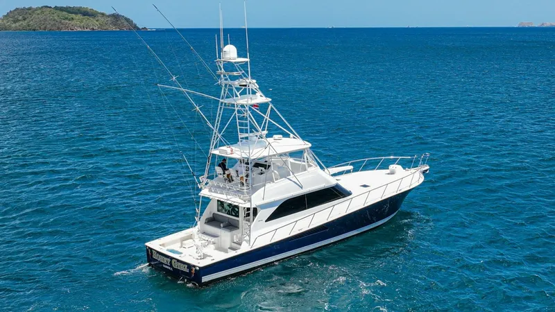 Slide: The Image of Aerial View of Fishing Yacht This image showcases the impressive Viking 61 Convertible, built in 2005, navigating the open waters. The vessel's sleek design and spacious aft deck are ideal for sport fishing and leisure. With its robust tower and elegant lines, 'Honey Girl' combines f - 6449582