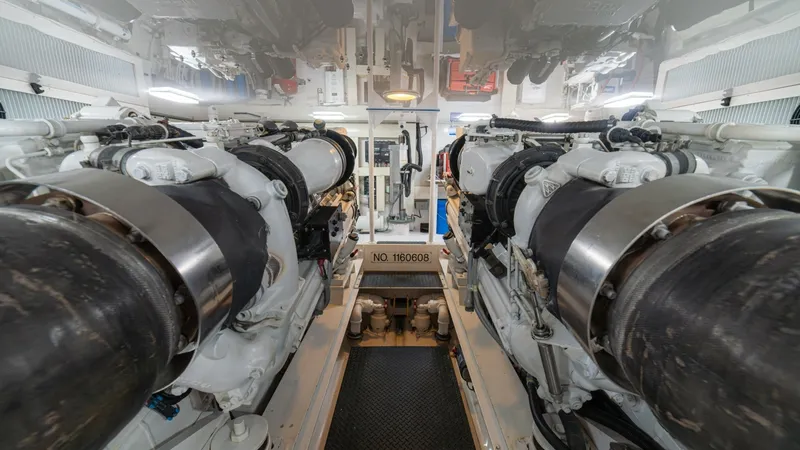 Slide: The Image of Engine Room with Dual Engines The engine room of the 2005 Viking 61 Convertible 'Honey Girl' showcases powerful dual engines, meticulously arranged for optimal performance. The space is well-organized with easy access to critical components, ensuring efficient maintenance. Bright over - 6449551