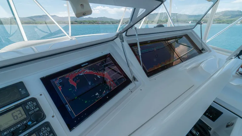 Slide: The Image of Helm Station with Navigation Displays The helm station of the 2005 Viking 61 Convertible 'Honey Girl' features sophisticated navigation displays, ensuring precise guidance on your voyages. The dual screens are prominently placed for optimal visibility, surrounded by additional control panels - 6449571