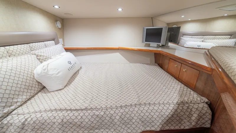 Slide: The Image of Forward Stateroom with TV This inviting forward stateroom offers a spacious double berth with elegant patterned bedding, complemented by warm wood cabinetry. The room features built-in storage and a convenient mounted TV for entertainment. Recessed lighting and soft wall finishes - 6449545