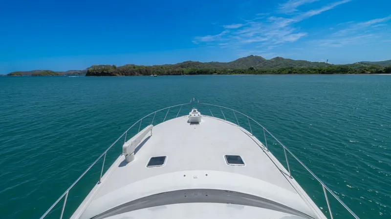 Slide: The Image of Bow View with Open Ocean Vista This image captures the sleek bow of the 2005 Viking 61 Convertible, 'Honey Girl', cutting through tranquil waters. The expansive deck offers a clear vantage point of the surrounding seascape, perfect for enjoying panoramic ocean views. The clean lines an - 6449581