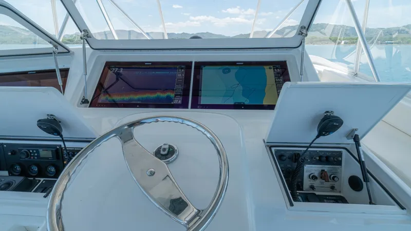 Slide: The Image of Flybridge Helm Station The helm station of the 2005 Viking 61 Convertible offers a panoramic view with advanced navigation systems. Featuring dual multifunction displays, this area ensures precise control and monitoring capabilities. The polished steering wheel and intuitive la - 6449569