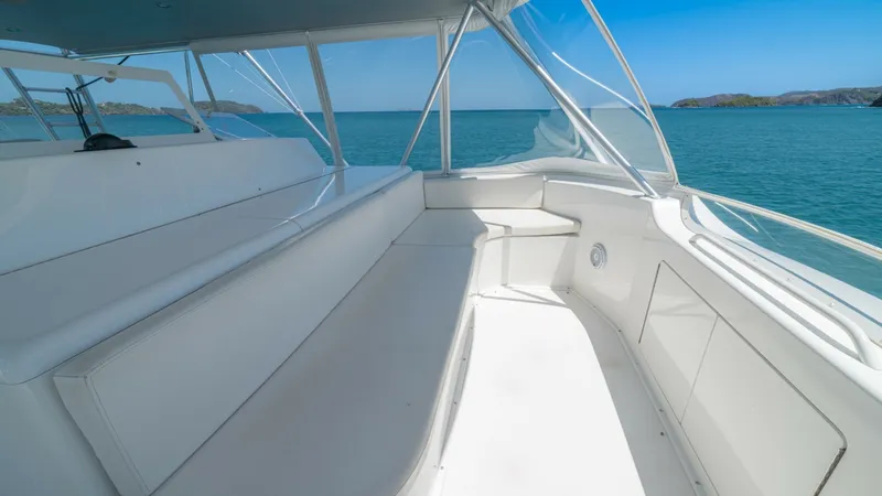Slide: The Image of Flybridge Seating Area The spacious flybridge of the 2005 Viking 61 Convertible, 'Honey Girl', features comfortable wrap-around seating with a panoramic view of the ocean. The sleek lines and clean white finish provide a modern, inviting atmosphere perfect for relaxation or ent - 6449575
