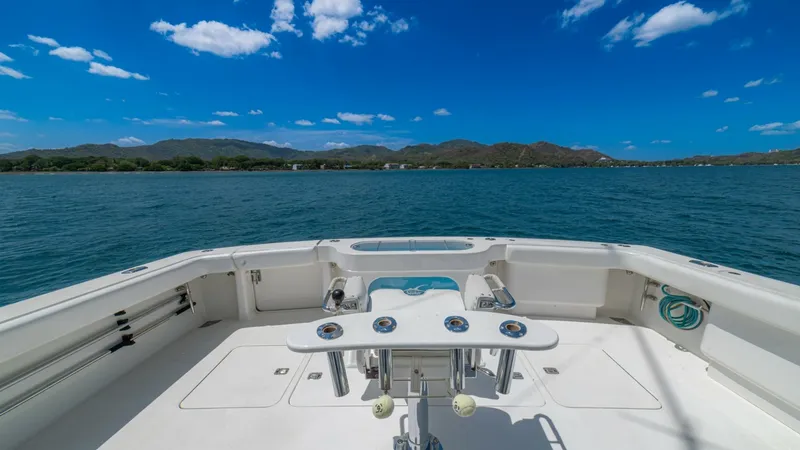 Slide: The Image of Spacious Aft Deck with Rod Holders The aft deck of the 2005 Viking 61 Convertible, Honey Girl, offers ample space for fishing enthusiasts, featuring multiple rod holders and a sturdy fighting chair. The clean, white finish complements the expansive views of the water, enhancing the outdoor - 6449557
