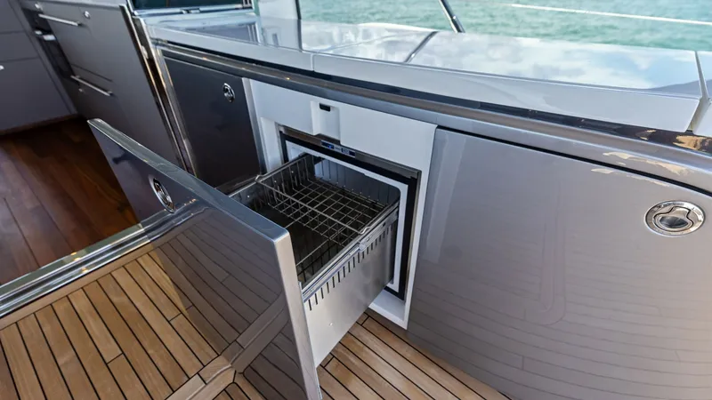 Slide: The Image of Cockpit Refrigerator The 2026 PRINCESS V55 features a sleek outdoor galley, perfect for entertaining. Highlighted by its pull-out drawer, this space combines functionality with modern design. The stainless steel finishes and teak decking provide both durability and elegance, - 6312336