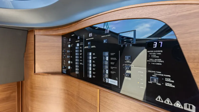Slide: The Image of Advanced Control Panel The 2026 PRINCESS V55 features a sleek and modern control panel, seamlessly integrated into the wooden cabinetry. This state-of-the-art system offers intuitive access to the yacht's essential functions, including water systems and power management. The er - 6312345