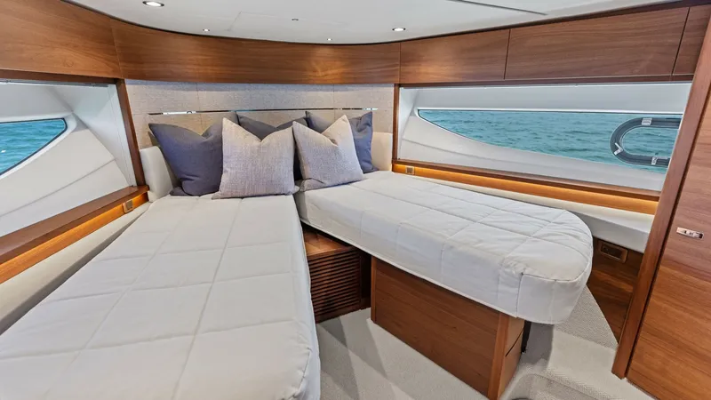Slide: The Image of VIP Stateroom 2 The VIP Stateroom forward twin cabin of the 2026 Princess V55 exudes modern elegance with its rich wood finishes and plush bedding. Large windows allow natural light to illuminate the space, offering stunning ocean views. Thoughtfully designed storage sol - 6312356