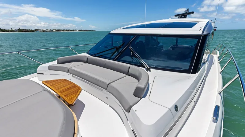 Slide: The Image of Spacious Bow Sunpad and Seating Area The 2026 Princess V55 features a luxurious forward sunpad, perfect for relaxing and enjoying panoramic ocean views. The sleek design includes plush cushions and a stylish teak accent table. This inviting space is ideal for sunbathing or socializing while - 6312368