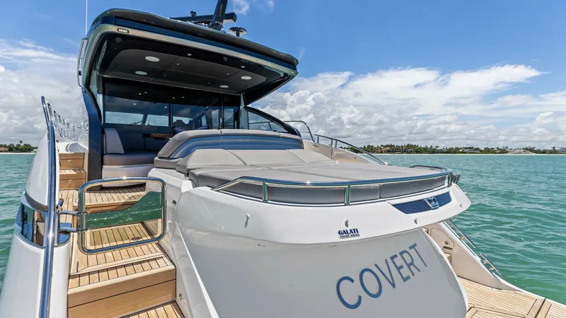 Slide: The Image of Cockpit Deck with Sunpad Lounger The aft deck of the 2026 PRINCESS V55 showcases a spacious sunpad lounger, perfect for soaking up the sun while cruising. The elegant teak decking complements the sleek lines of the yacht, enhancing its luxurious appeal. The stylish overhang provides shad - 6312371